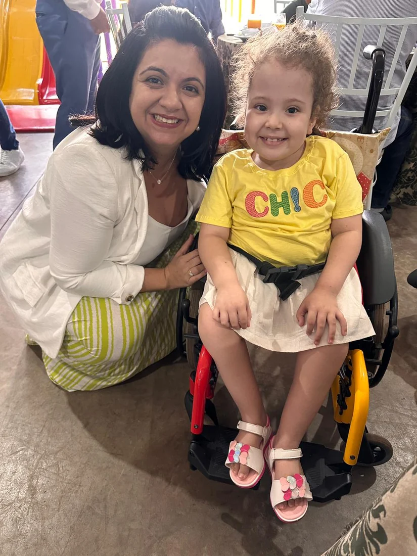Alê Portela falando ao microfone com o livro Corações Puros em mãos